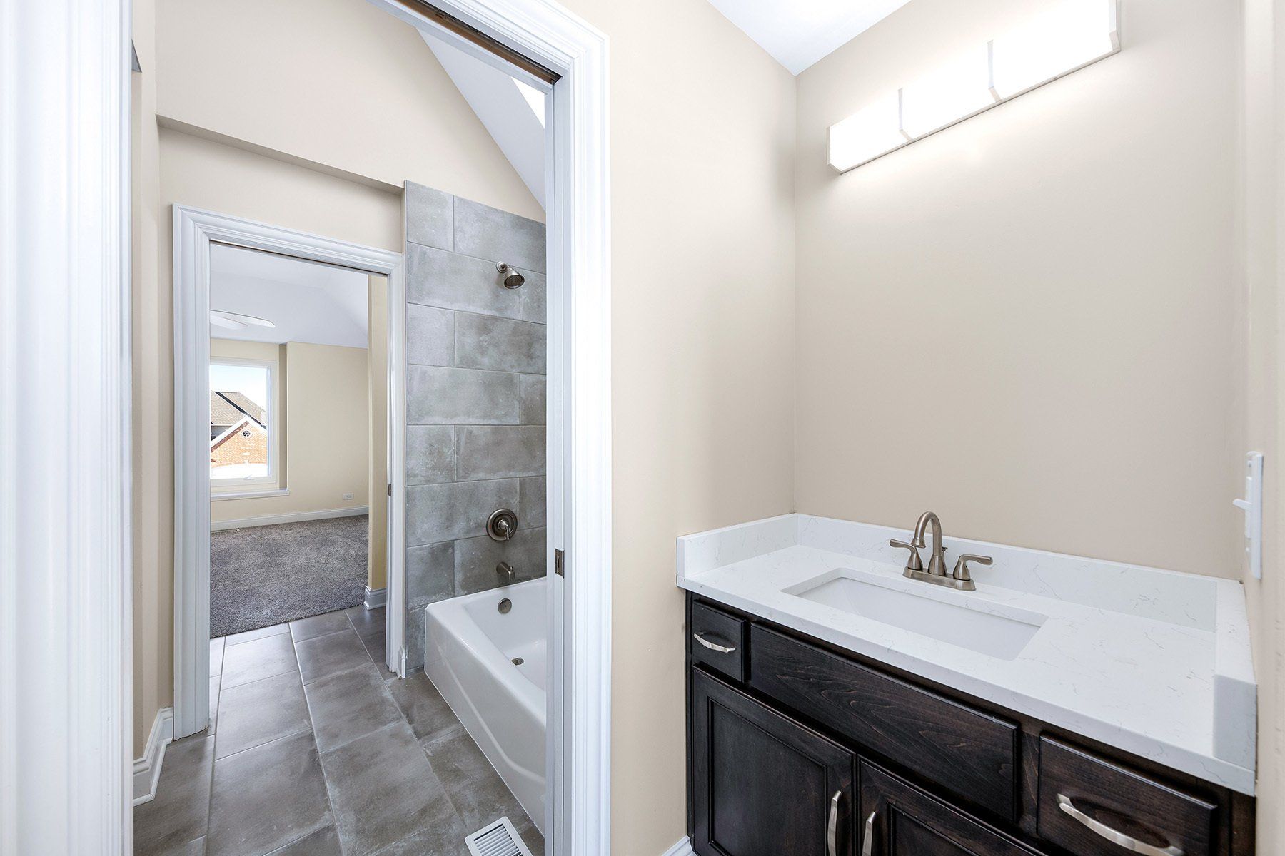 A bathroom with a sink , tub and shower.