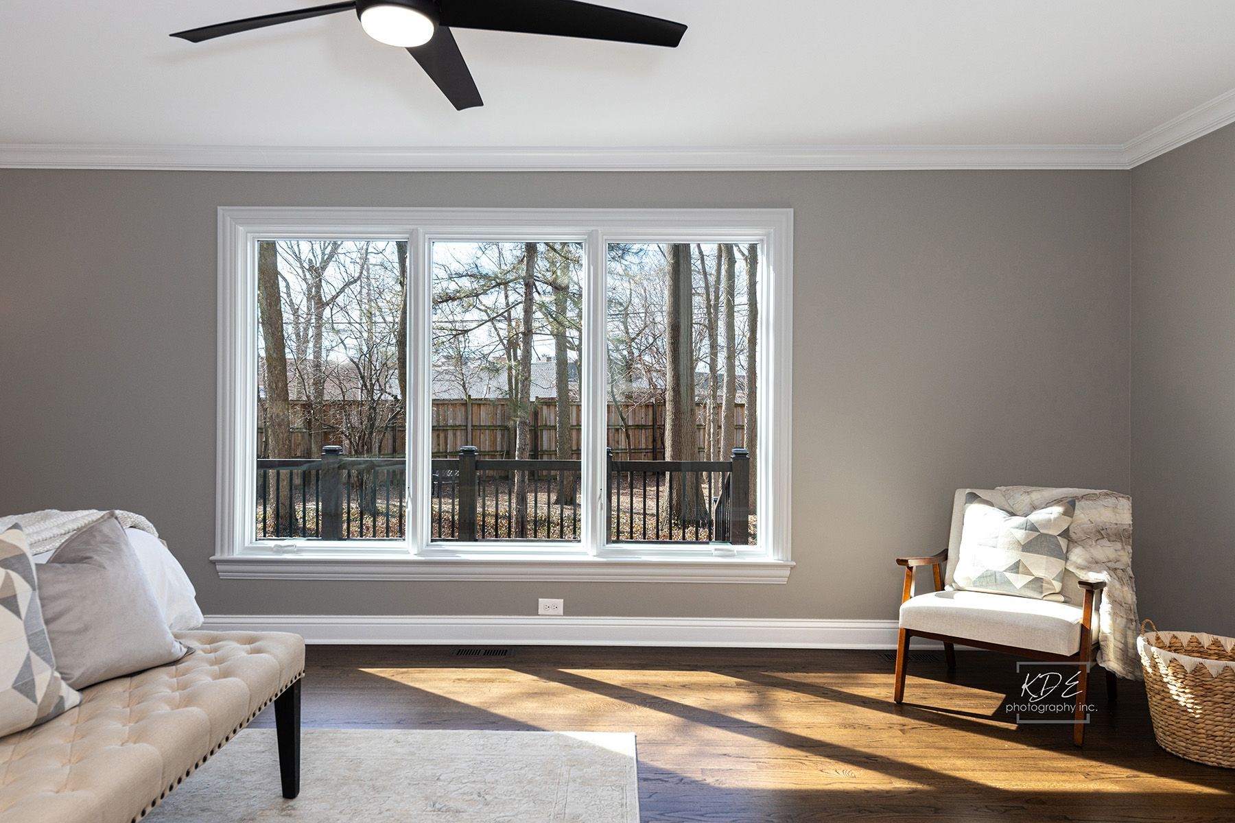 A living room with a couch , chair , and ceiling fan.