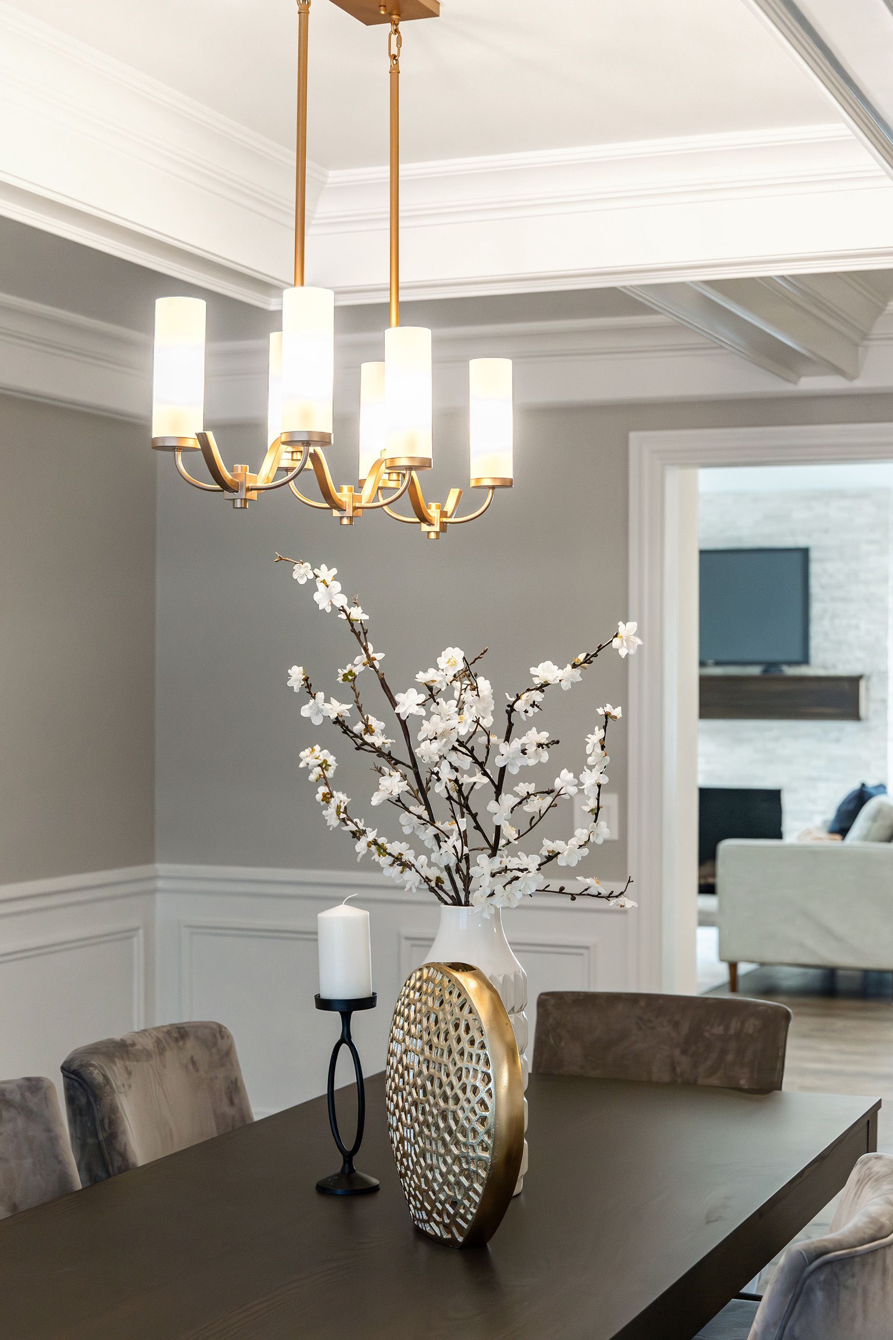 A dining room table with a vase of flowers and a candle on it.
