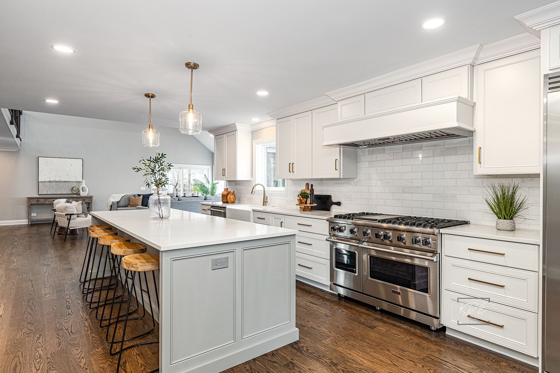A kitchen with white cabinets , stainless steel appliances , and a large island.