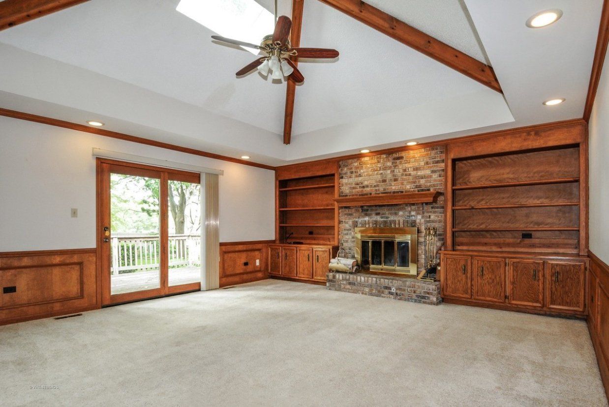 A living room with a fireplace and a ceiling fan