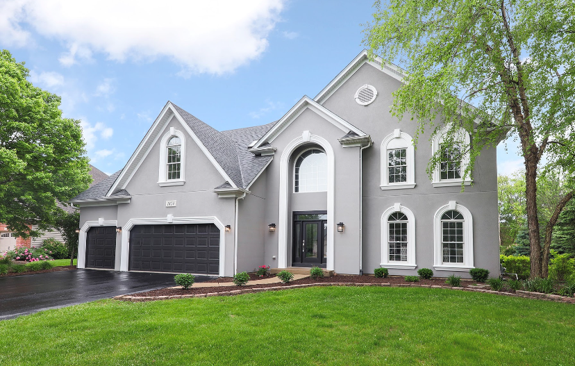 A large house with a lot of windows and a large driveway