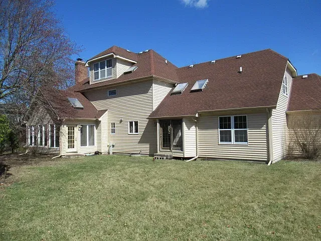 A large house with two garages and a lush green lawn.