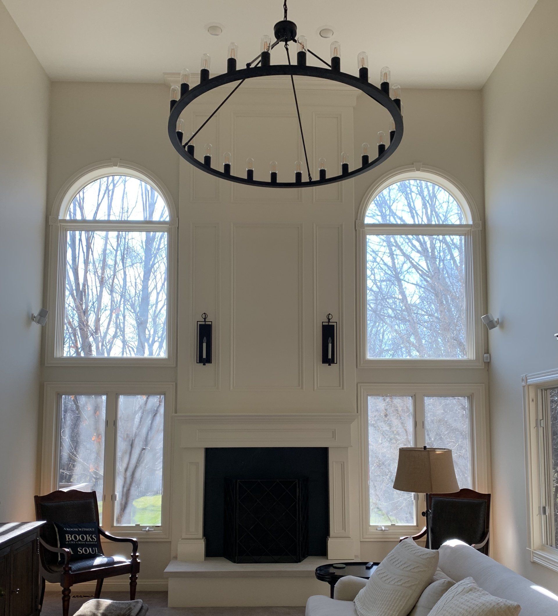 A living room with a fireplace and a chandelier hanging from the ceiling