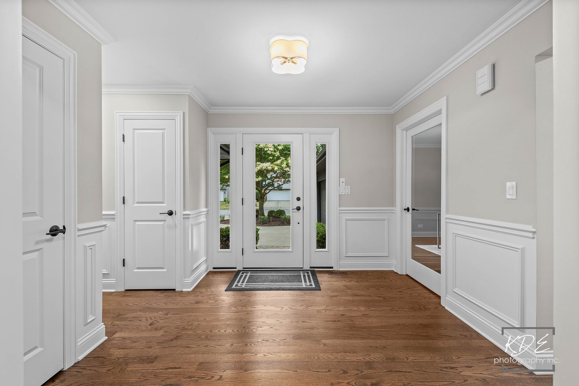 A hallway with hardwood floors and white doors in a house.