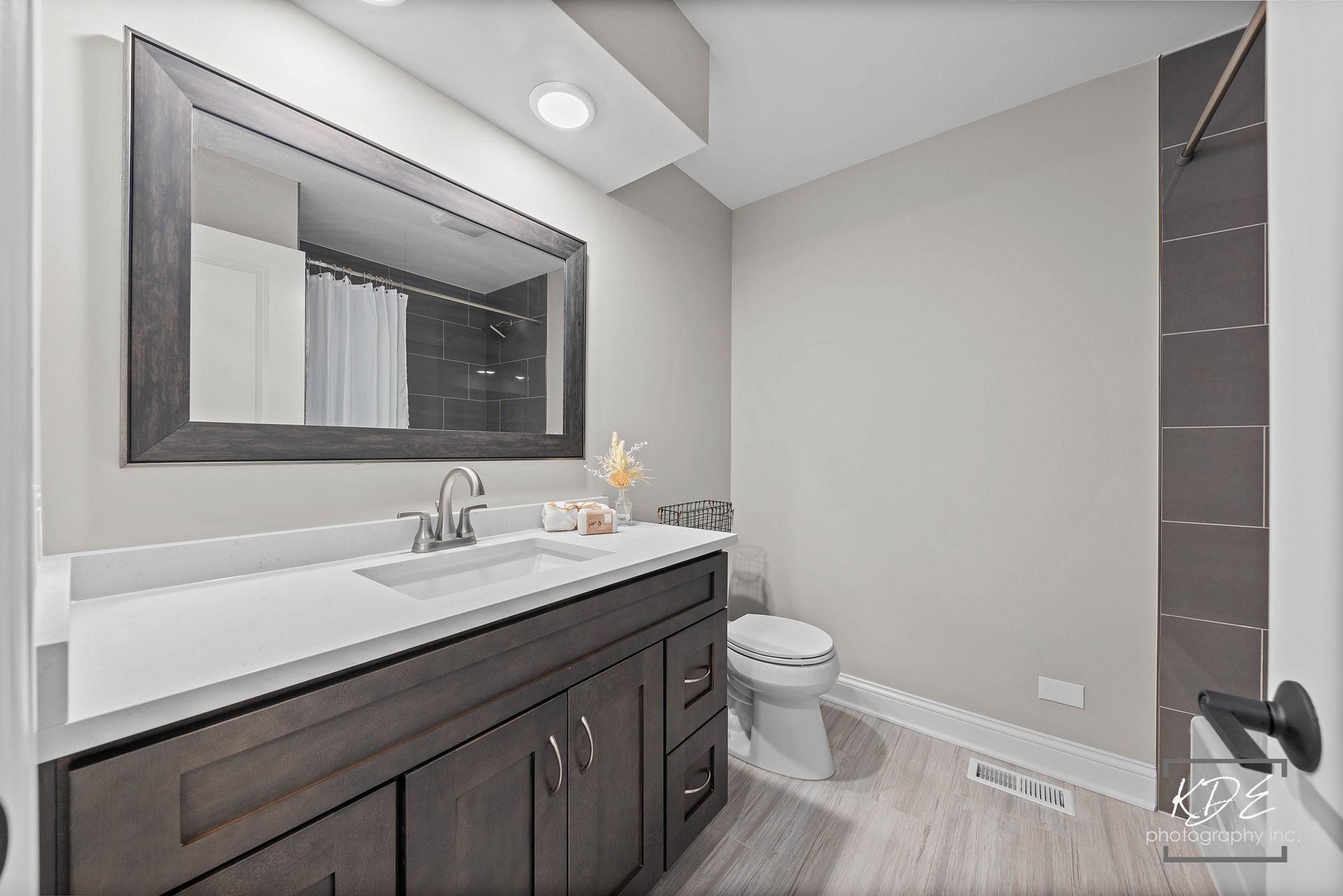 A bathroom with a sink , toilet and mirror.