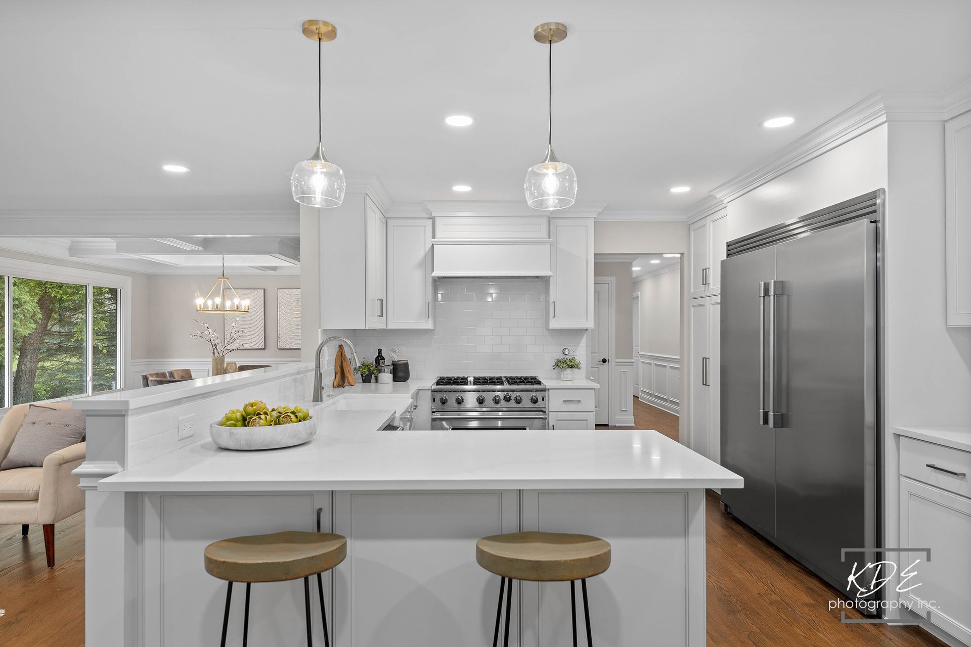 A kitchen with white cabinets , stainless steel appliances , and a large island.