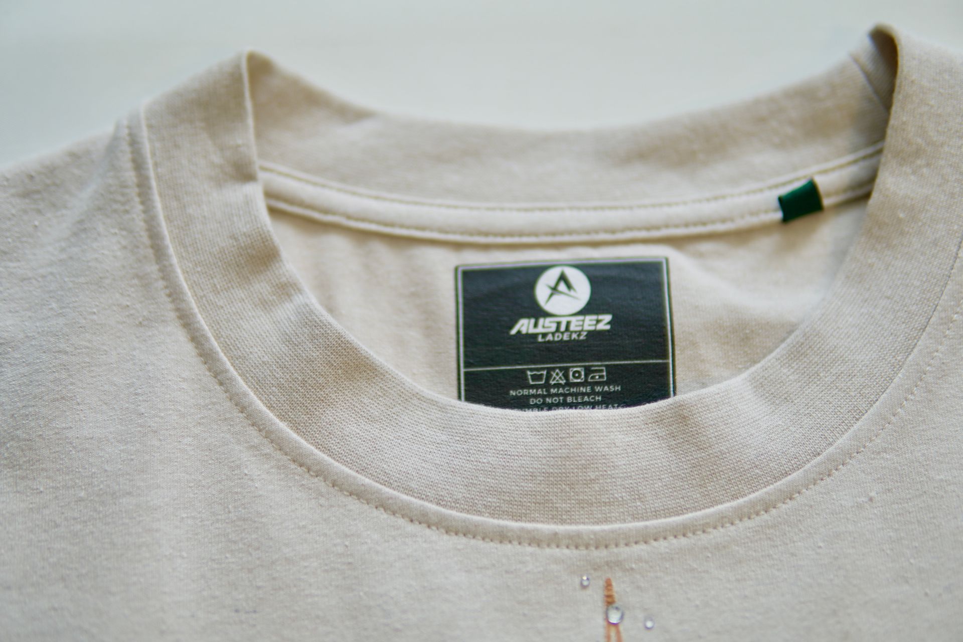 Close-up of a cream-colored shirt collar with a dark tag showing the brand 