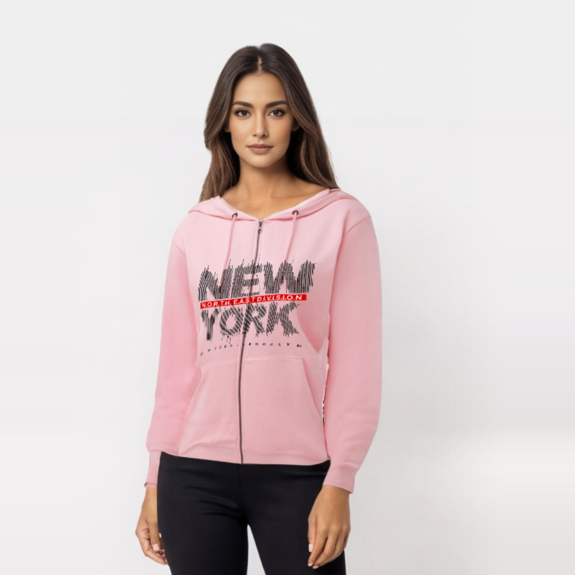 Woman in a pink zip-up hoodie, black pants, with "NEW YORK" graphic.