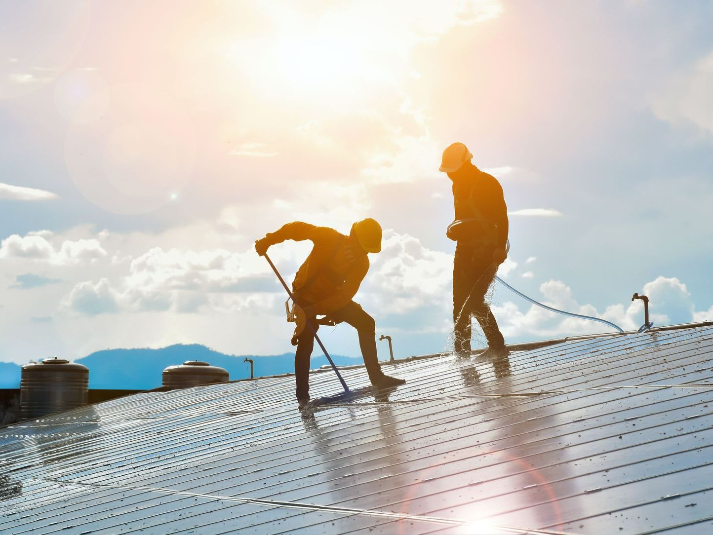 Photovoltaic technicians were cleaning and washing the surface of the solar panels which had dust and birds' pooping