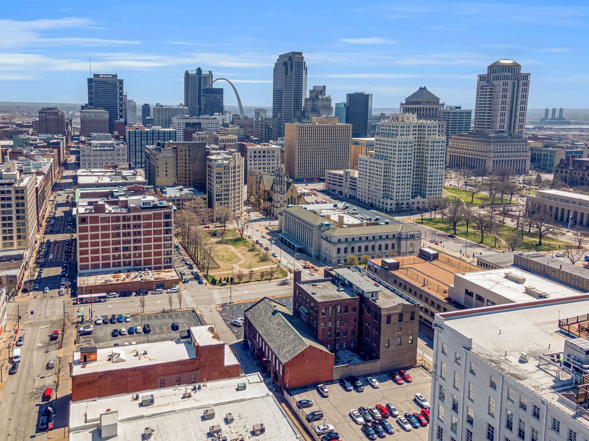 Downtown city skyline with high-rise buildings and parking lots under a clear blue sky