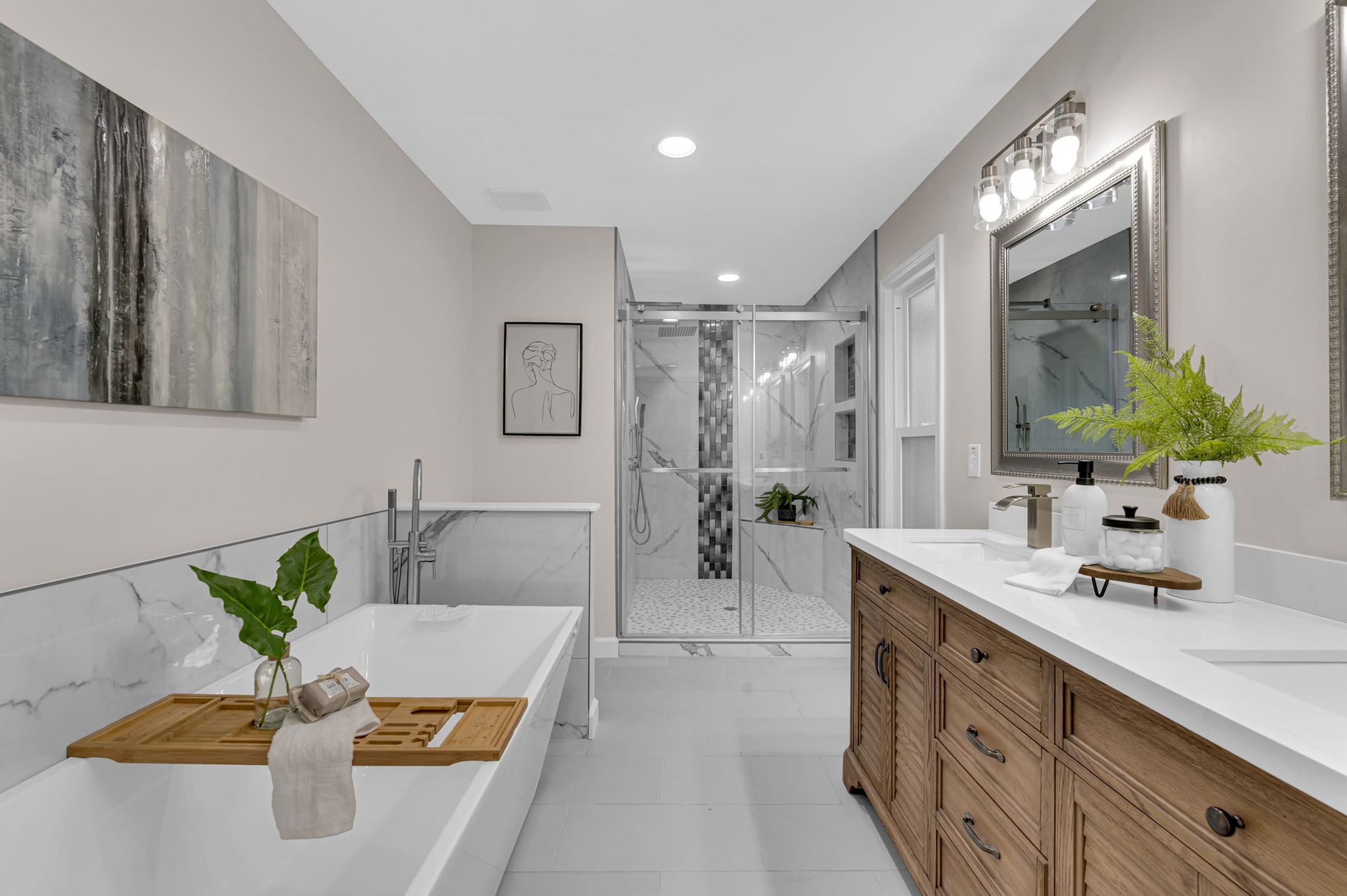 Bright modern bathroom with white tile, wooden vanity, mirror, and a shower at the back.