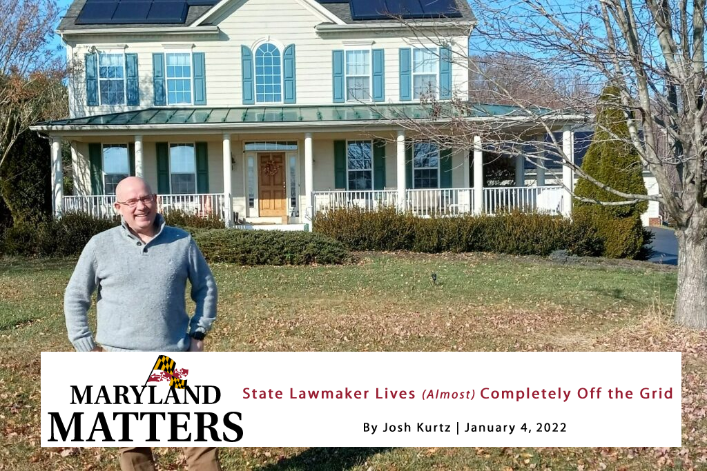 Man standing in front of a house with a banner reading “Maryland Matters” and a headline about a lawmaker.
