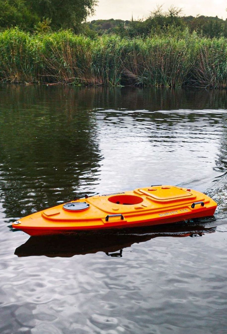 Een oranje kajak drijft op een rivier.