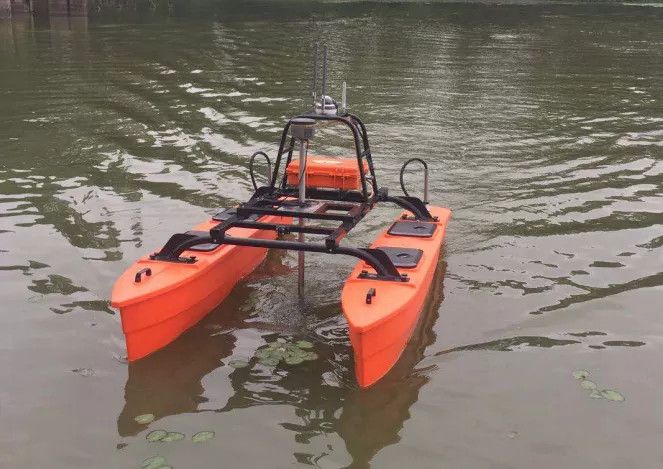 Een kleine oranje boot drijft op een watermassa