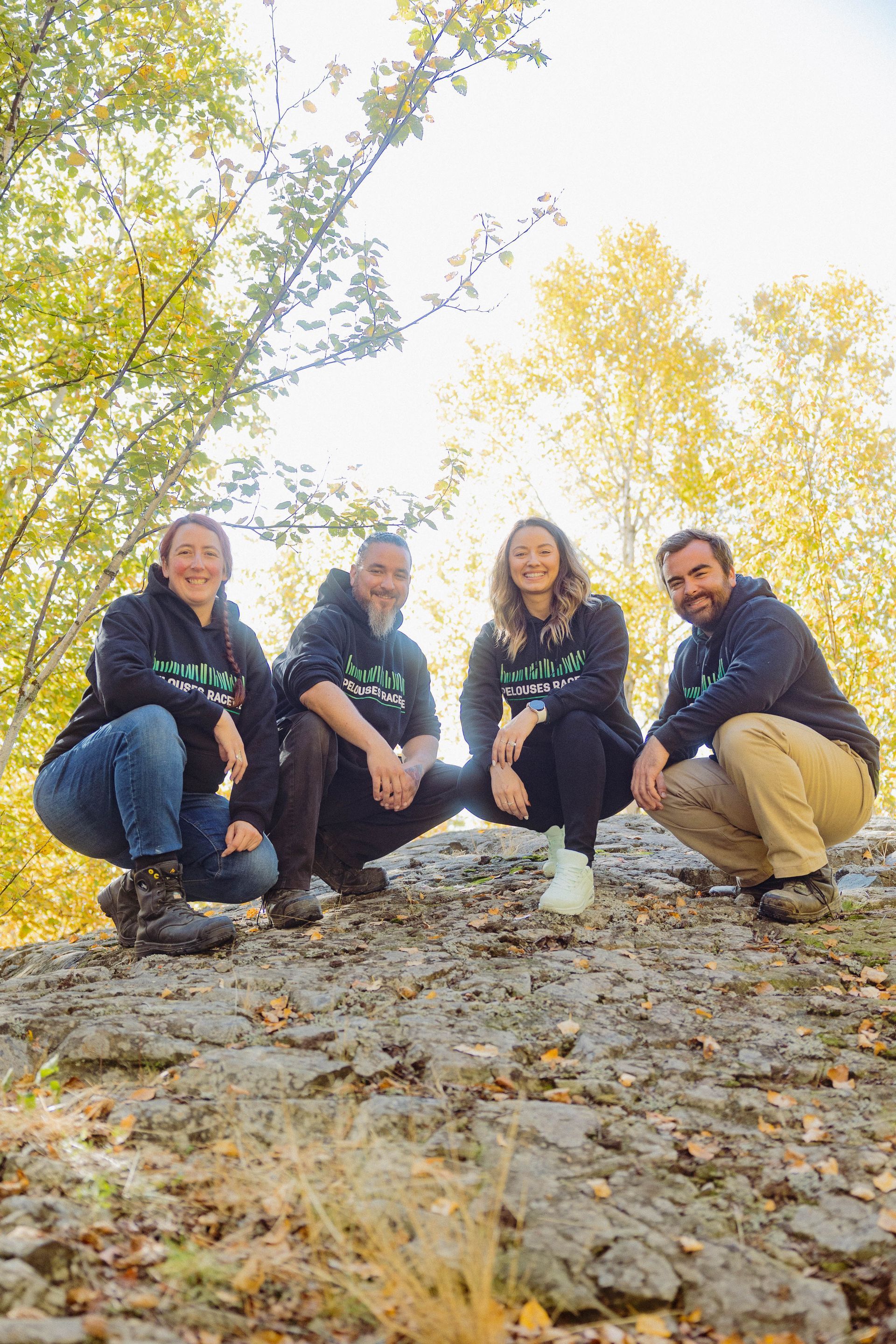 Un groupe de personnes est assis au sommet d’un rocher dans les bois.