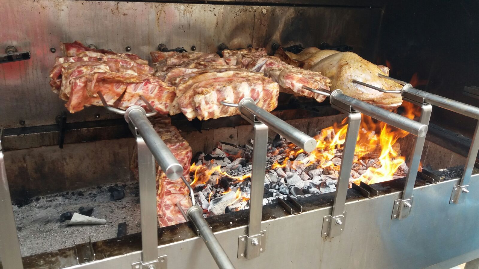 La carne viene cotta su una griglia con le fiamme dietro