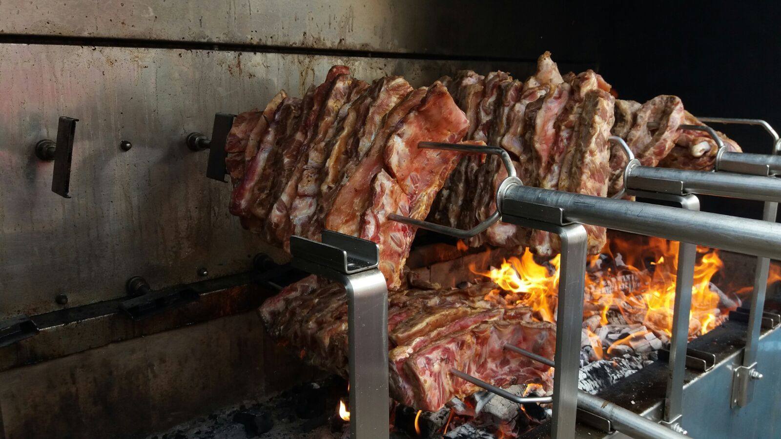 Un grosso pezzo di carne viene cucinato su una griglia.