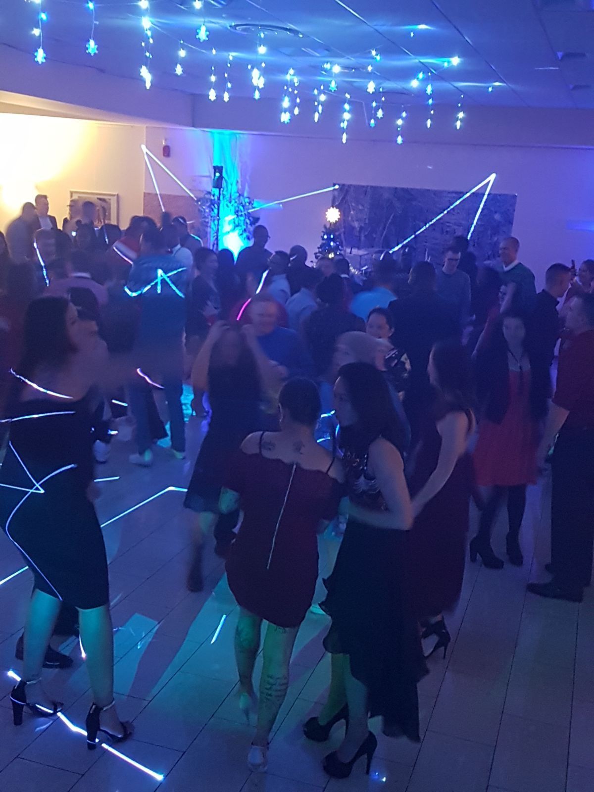 Un folto gruppo di persone sta ballando in una stanza buia.