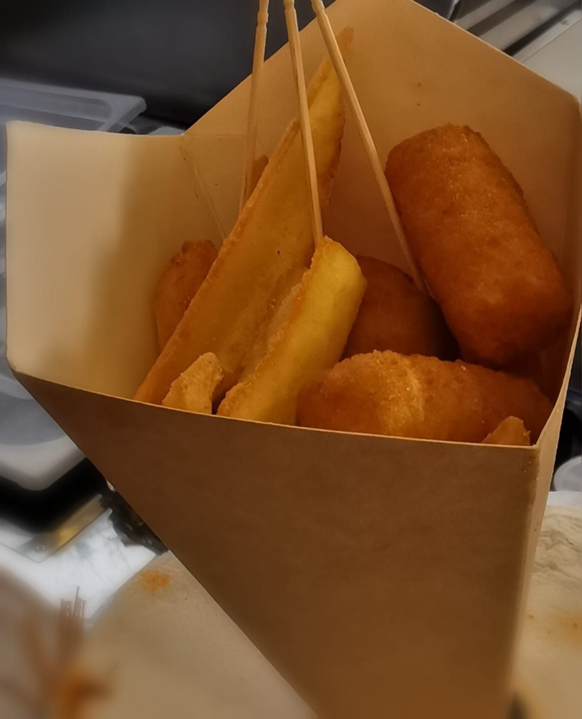 Un sacchetto di carta marrone pieno di corn dog e patatine fritte