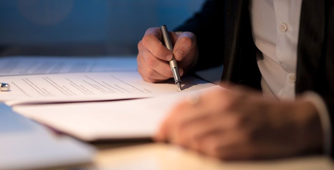 a person is writing on a piece of paper with a pen