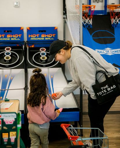A woman and a little girl are playing Hot Shot at The Lemon Lounge Indoor Playground