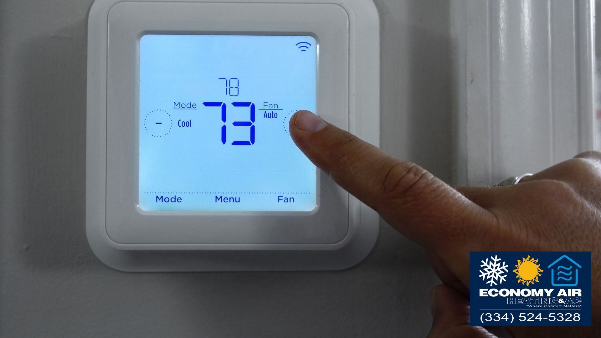 A person is adjusting a thermostat with their finger.