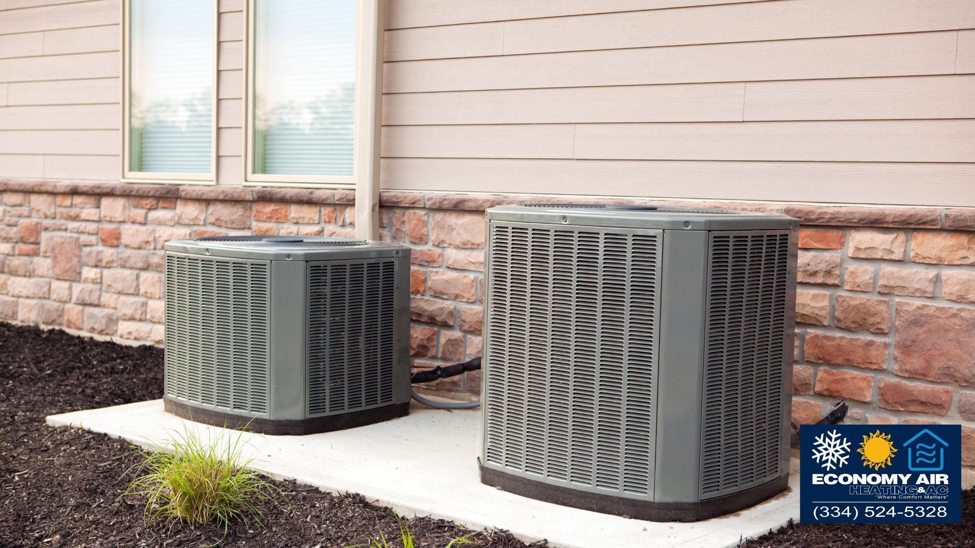 Two air conditioners are sitting on the side of a house.
