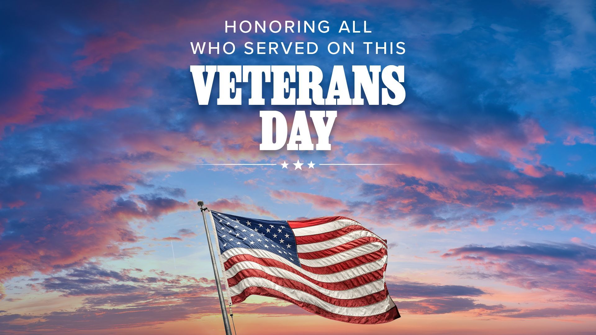 Veterans Day tribute with American flag against a colorful sunset sky and the message “Honoring all who served.”