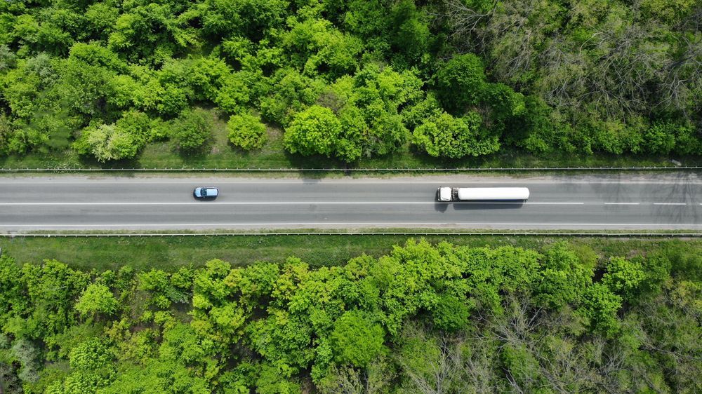 a car and truck are driving on the road — Crokers Fuel & Oils Pty Ltd in Paget, QLD