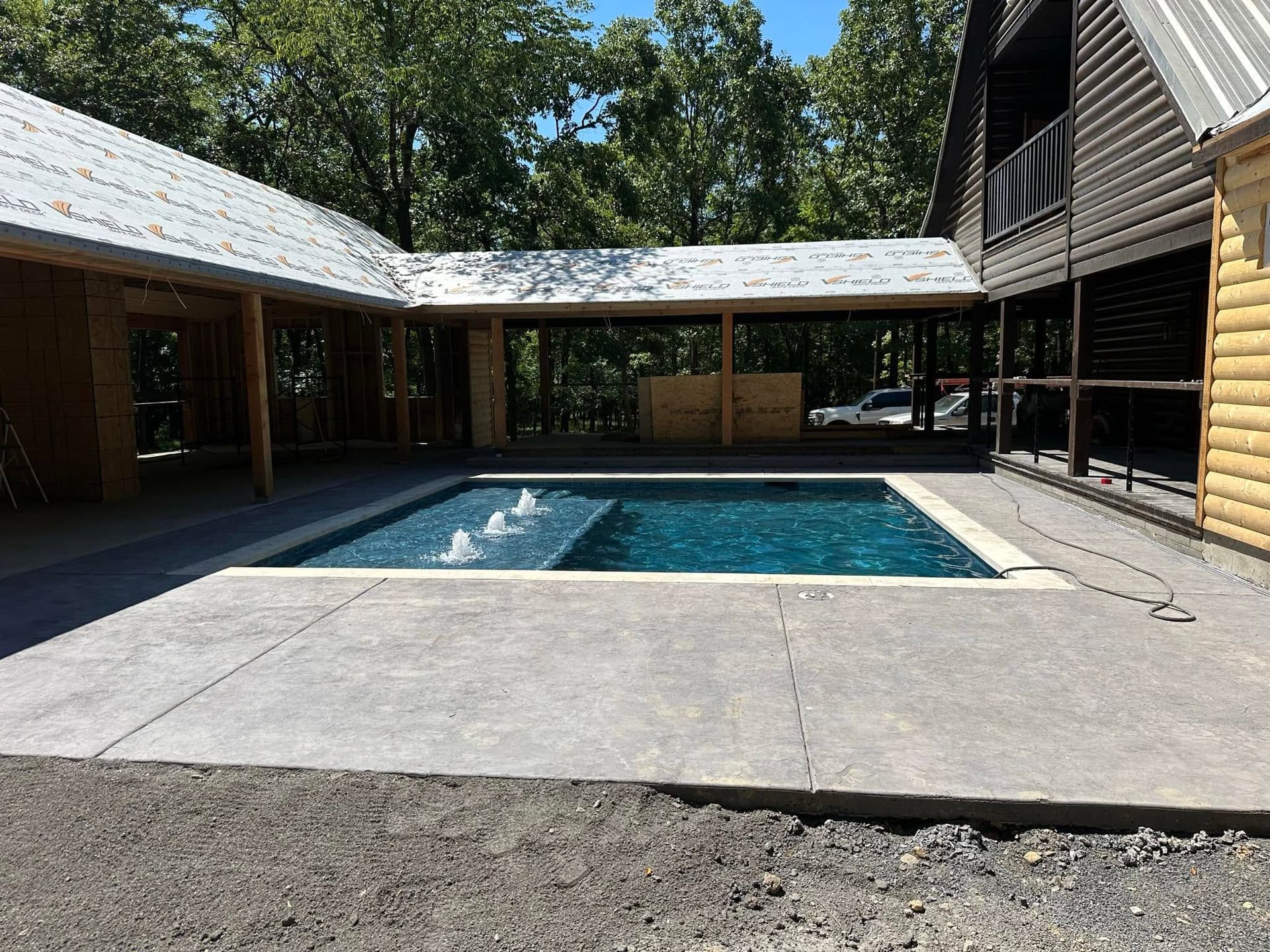 Modern house courtyard with a rectangular swimming pool and concrete patio
