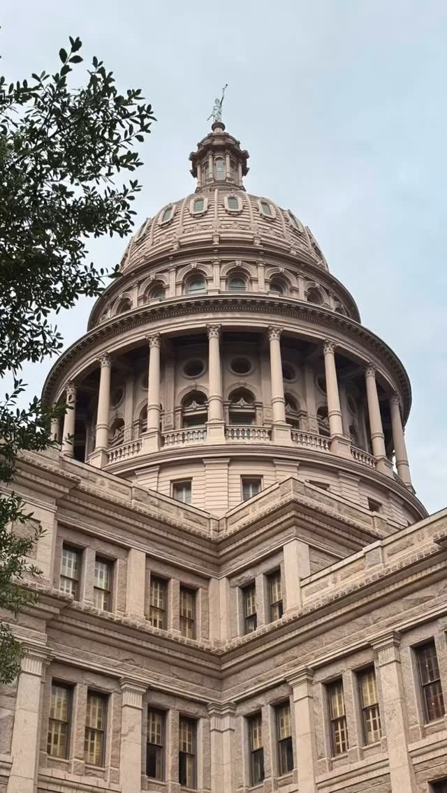 Close-up of a domed historic stone building against a pale blue sky