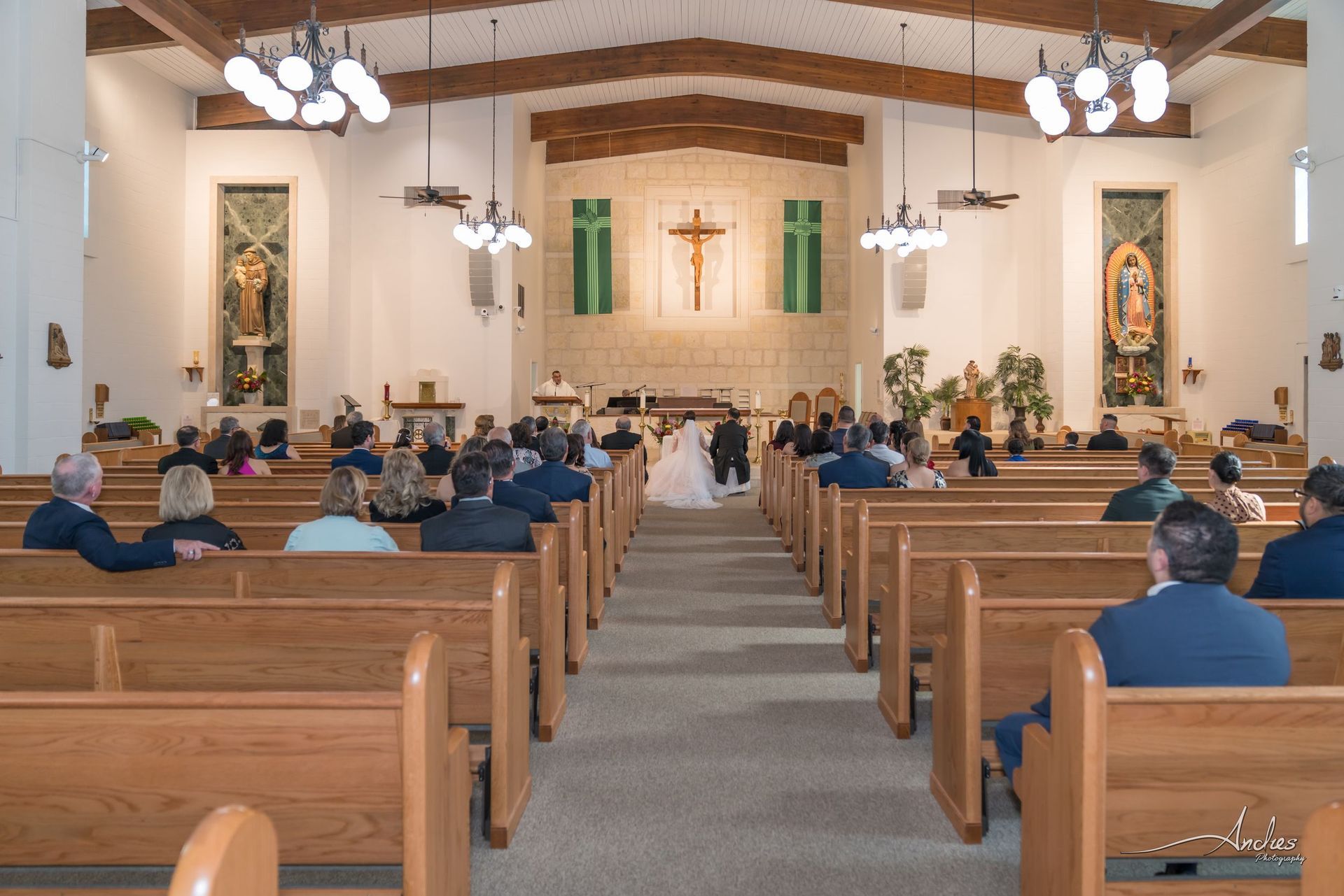 Church sanctuary with people seated in pews facing the altar and cross at the front