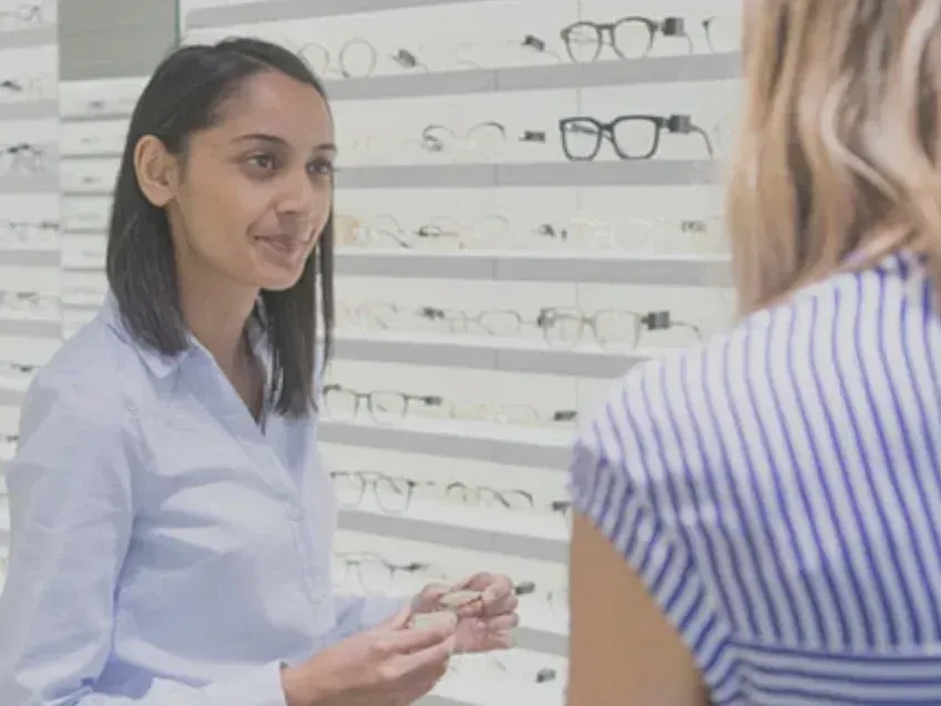 Optician Smiling at Her Client A woman is talking to another woman in an optical shop.