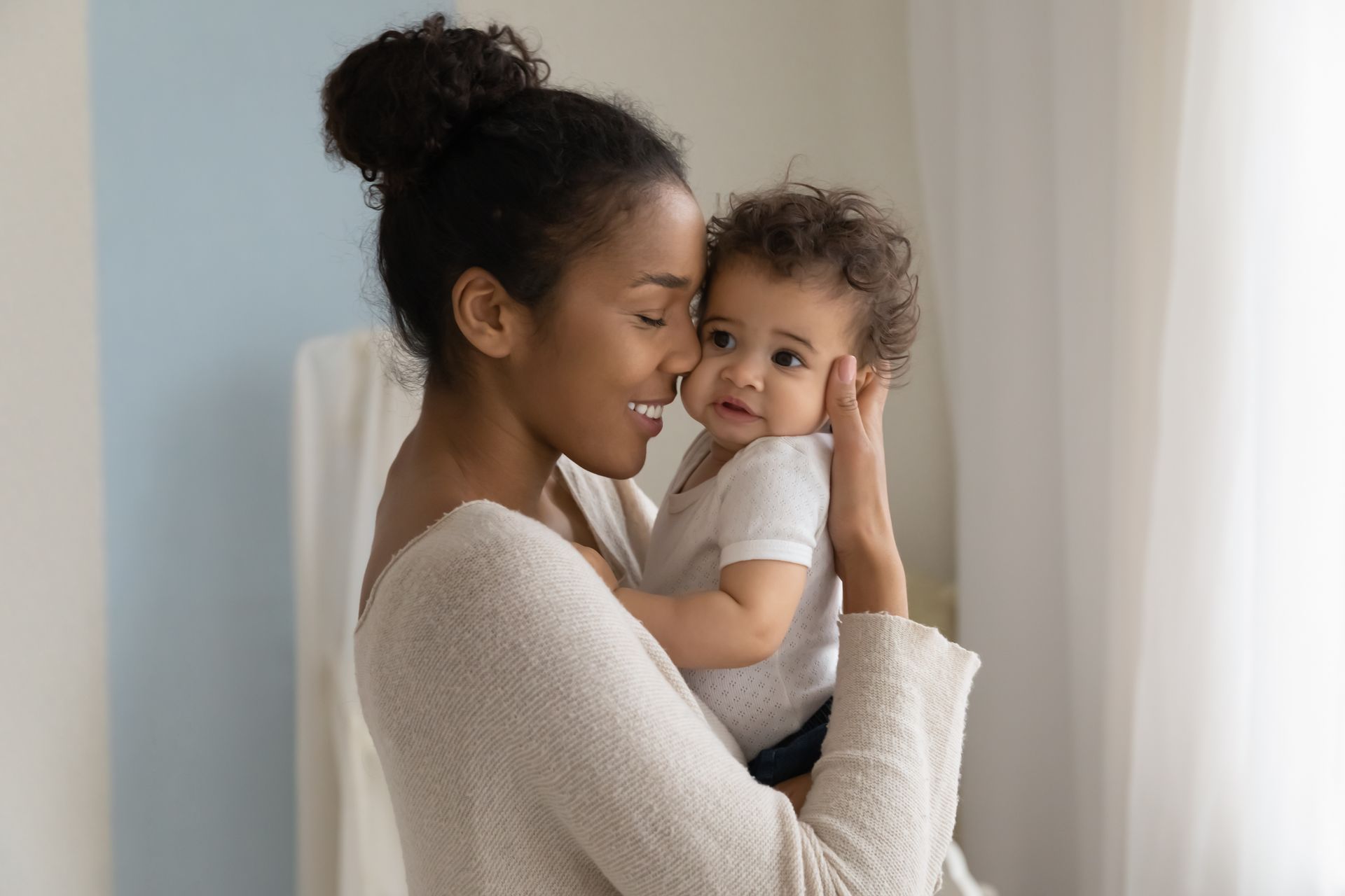 A woman is holding a baby in her arms.