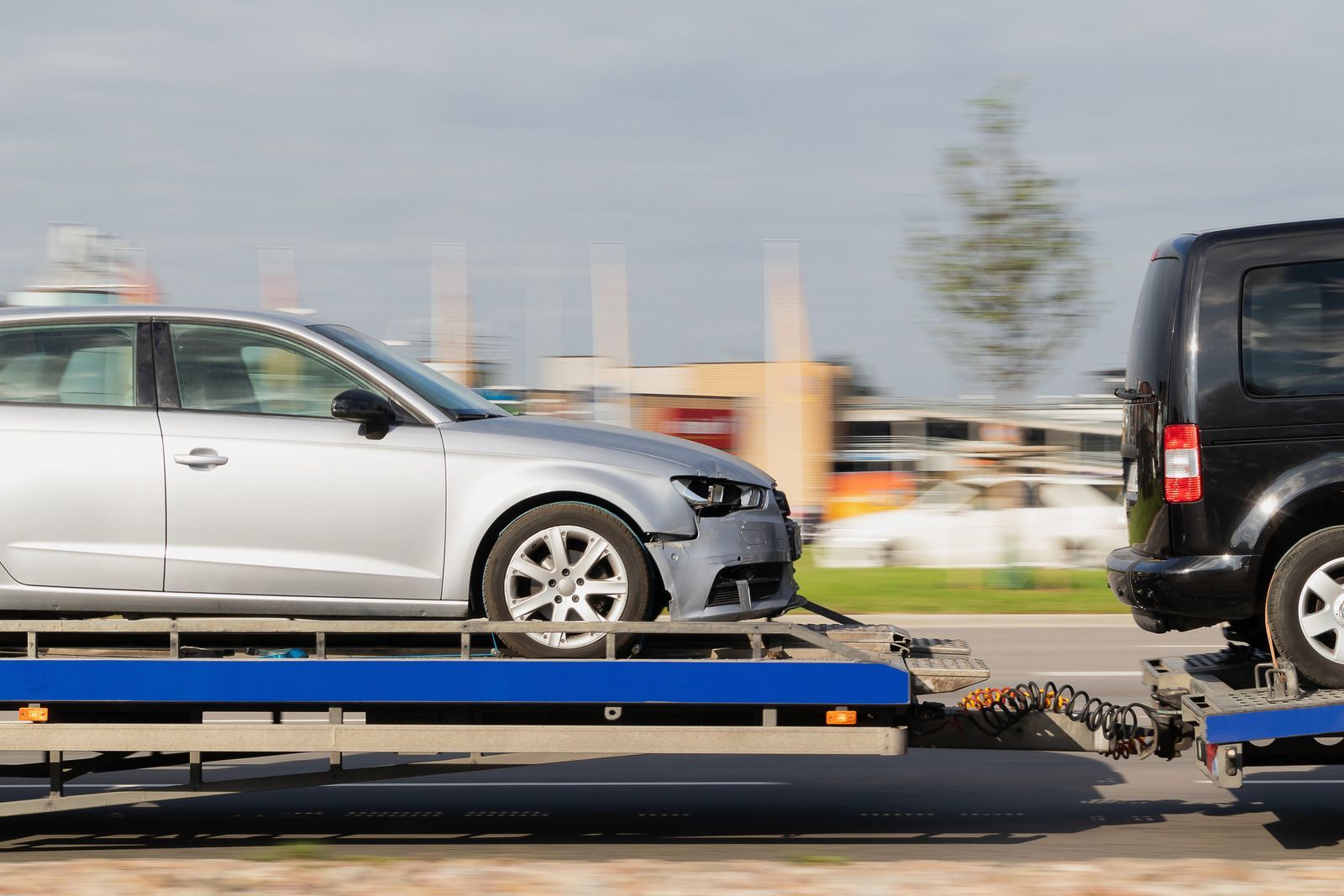 A car is being towed by a tow truck.