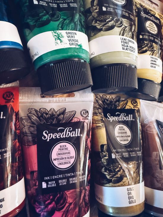 Assorted Speedball embroidery floss skeins in black, white, gold, and green on store shelves