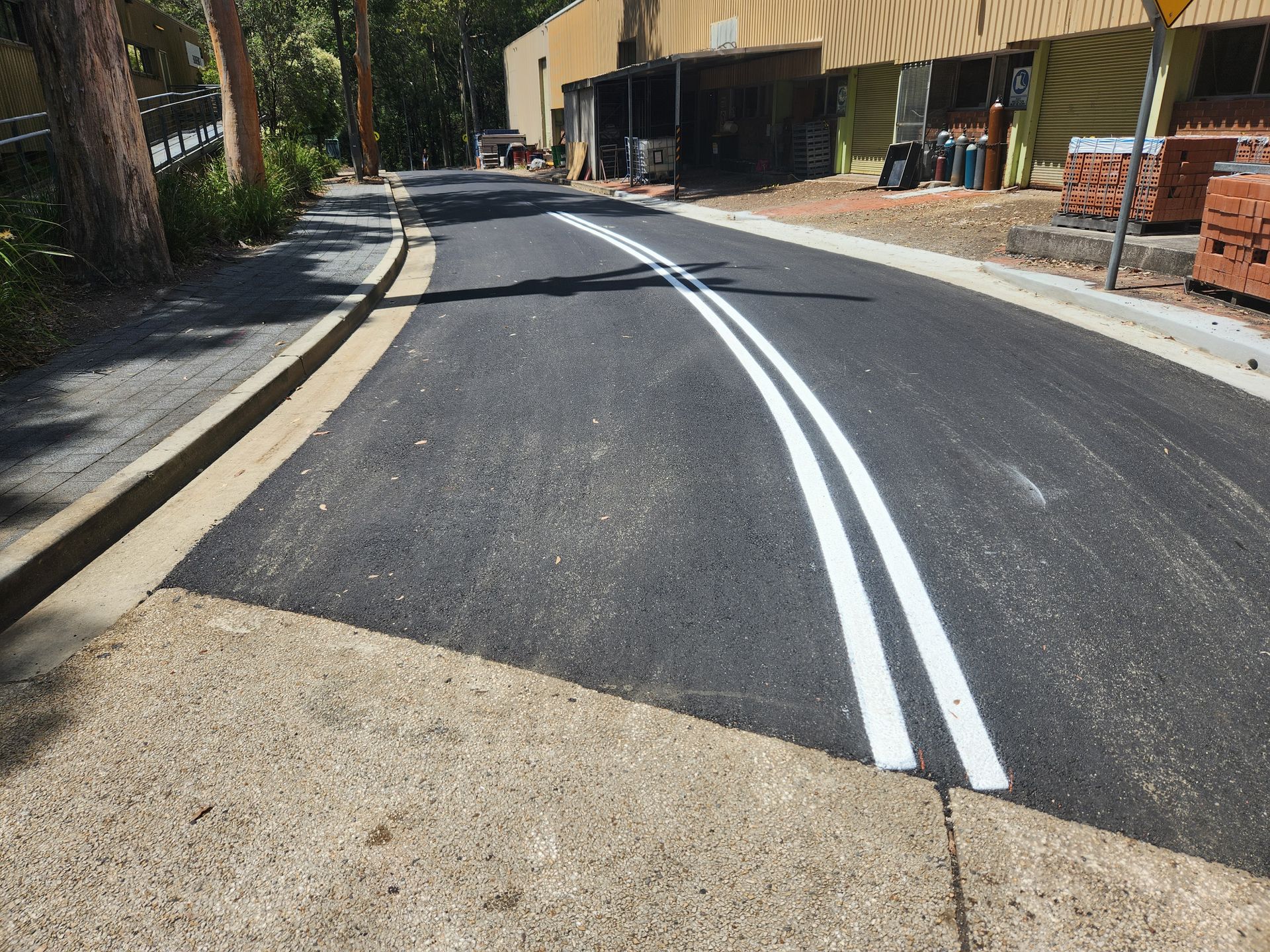 Newly Paved Road With Double White Lines, Concrete Curb — TAC Asphalt Services in Central Coast, NSW