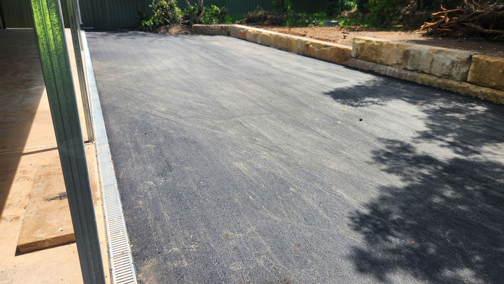 Gravel Driveway Bordered by Concrete and Retaining Wall — TAC Asphalt Services in Warners Bay, NSW
