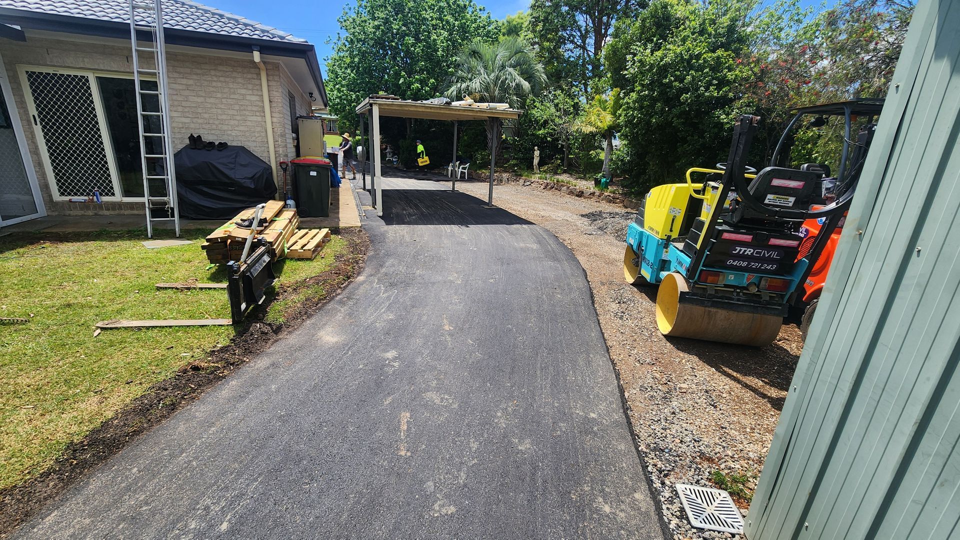 Asphalt Driveway Leading to a Canopy Construction Equipment — TAC Asphalt Services in Lake Macquarie, NSW