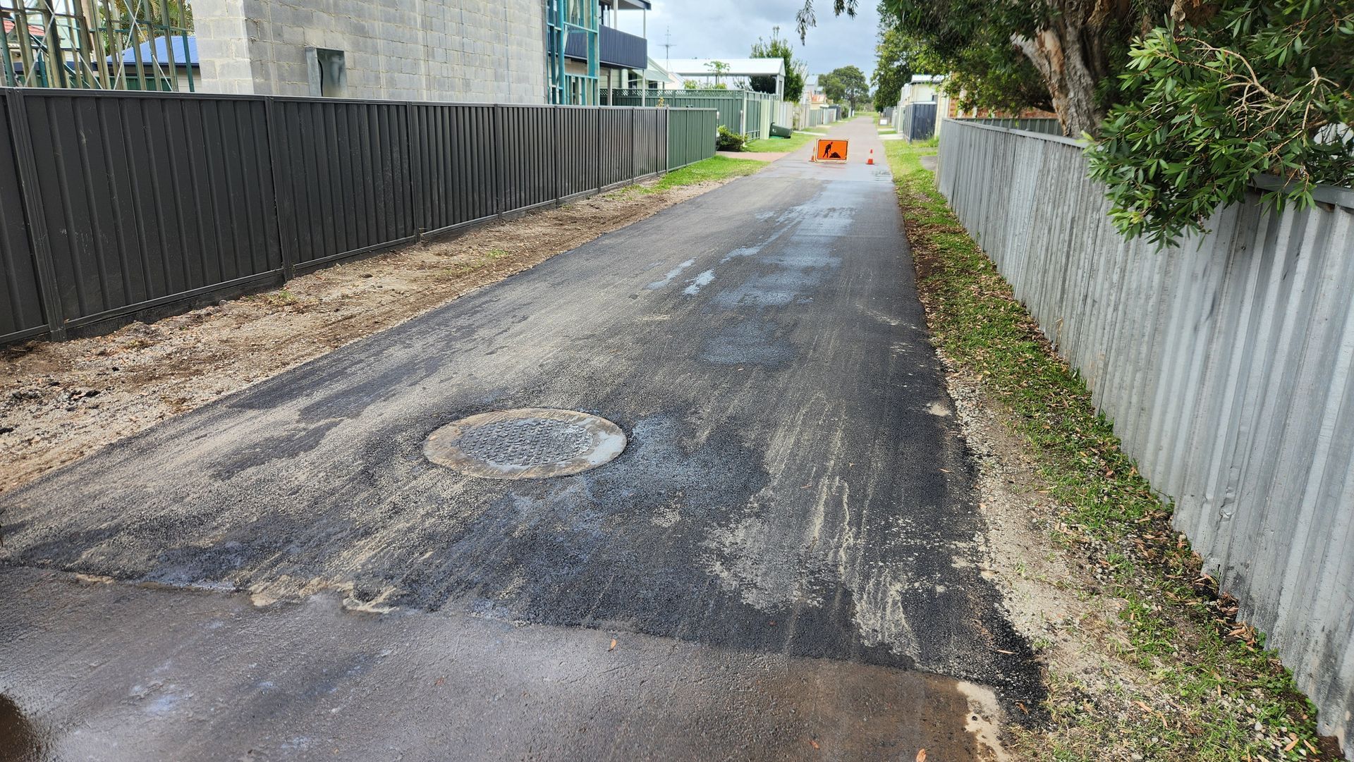 Asphalt Alley With A Sewer Lid, Fenced On Both Sides — TAC Asphalt Services in Warners Bay, NSW
