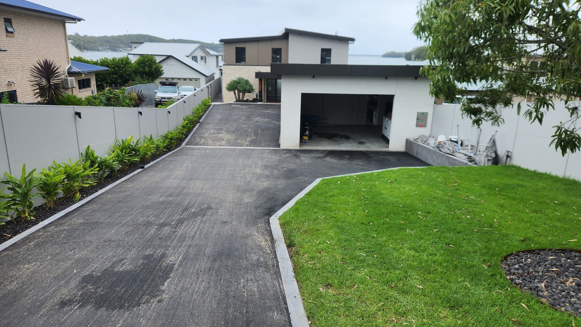 Driveway Leading To Garage Of A Modern Two-story Home — TAC Asphalt Services in Warners Bay, NSW