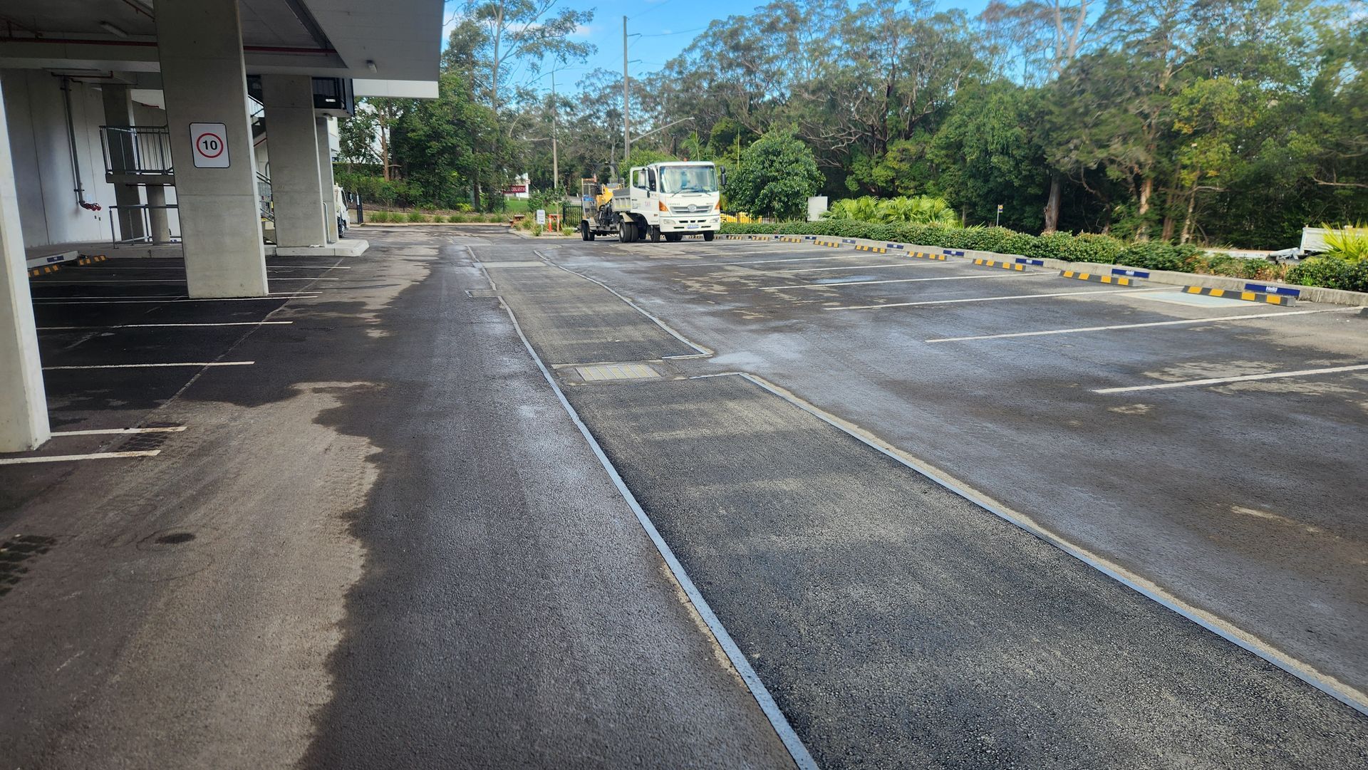 Paved Parking Lot With A Vehicle In The Distance — TAC Asphalt Services in Warners Bay, NSW