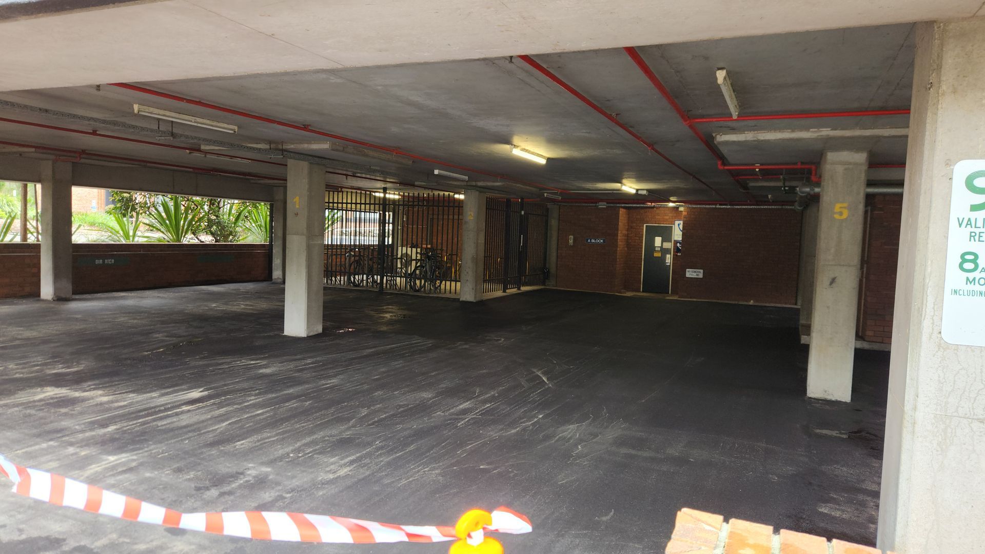 Empty, Open-air Parking Garage With Gray Concrete Pillars, Black Asphalt Floor — TAC Asphalt Services in Warners Bay, NSW