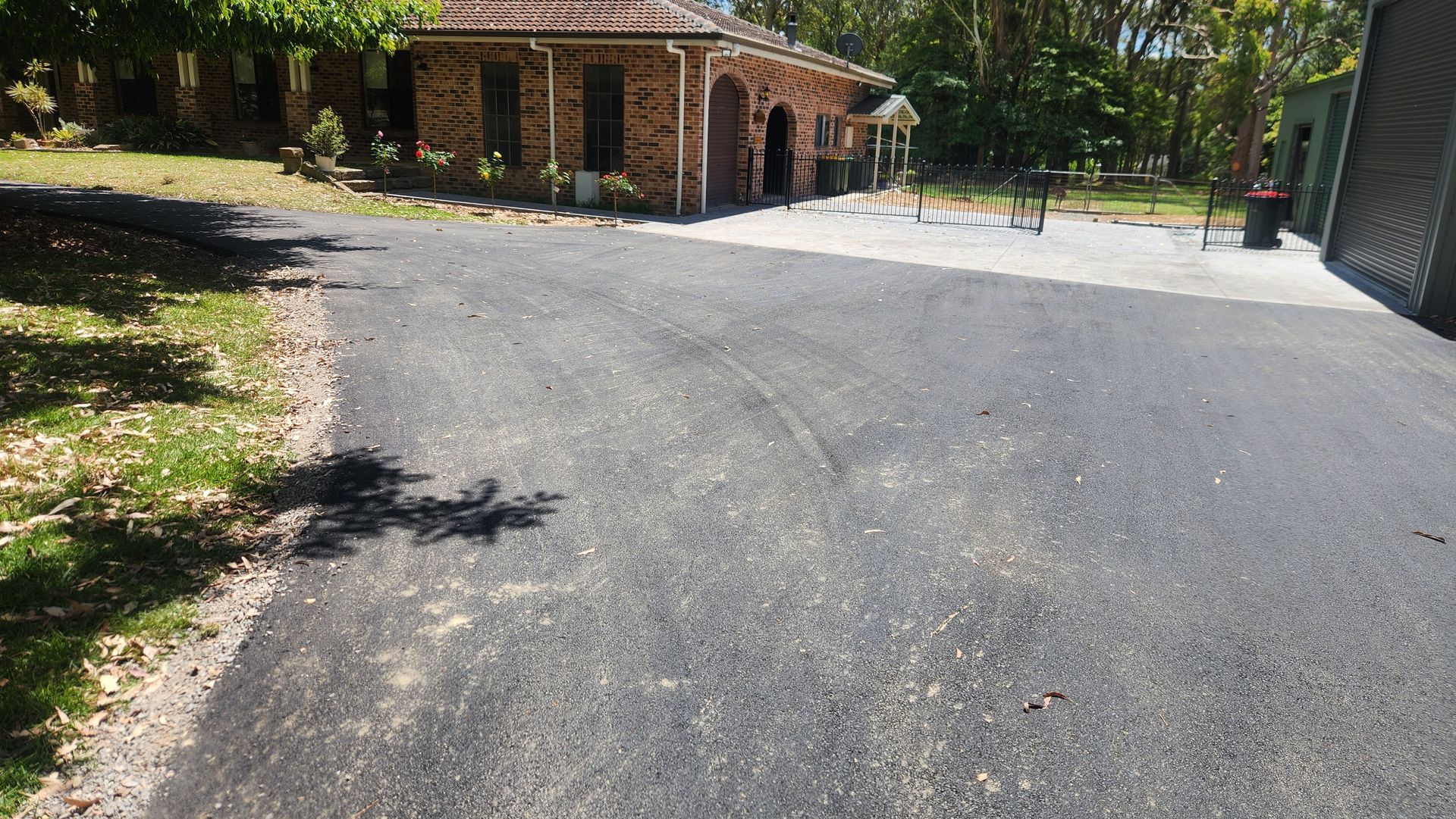 Asphalt Driveway Leading to a Brick Building With a Playground to the Right — TAC Asphalt Services in Hunter Valley, NSW