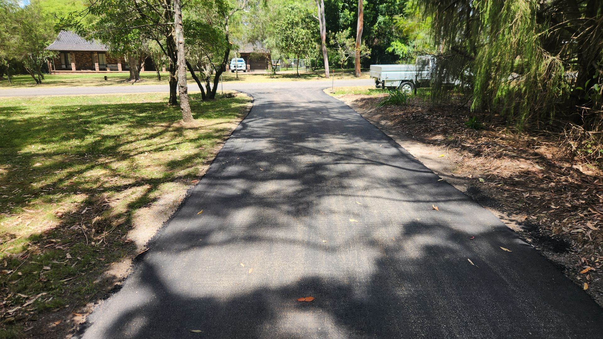 Paved Pathway Through A Park With Trees And Buildings — TAC Asphalt Services in Warners Bay, NSW