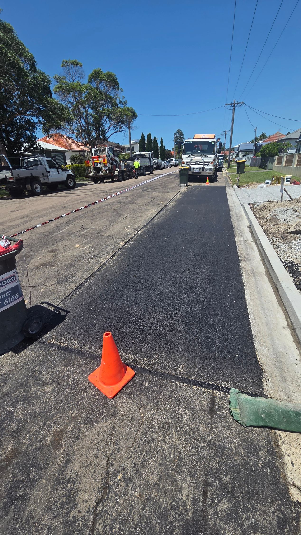 Road Resurfacing in Progress; Truck, Cone, Fresh Asphalt — TAC Asphalt Services in Warners Bay, NSW