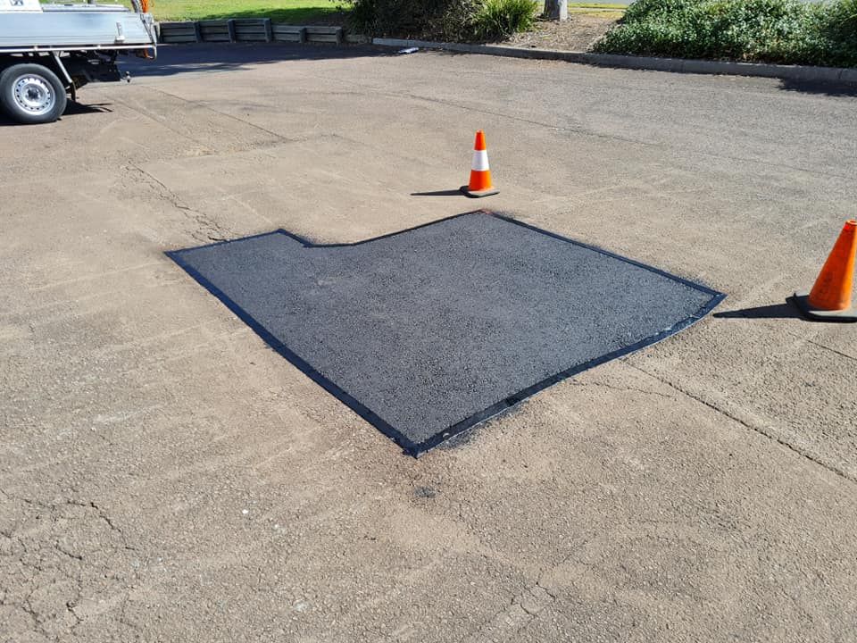 Asphalt Repair in a Parking Lot, Marked by Cones — TAC Asphalt Services in Warners Bay, NSW