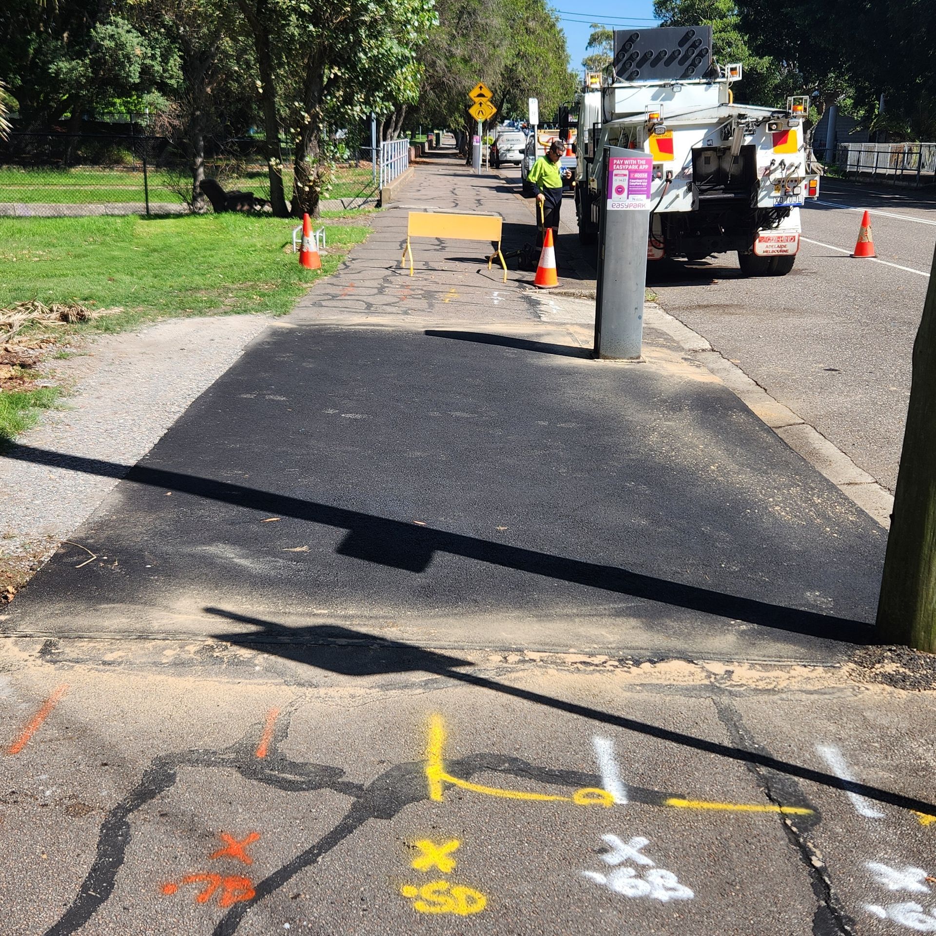 Asphalt Patch On A Paved Pathway With Orange Cones — TAC Asphalt Services in Warners Bay, NSW