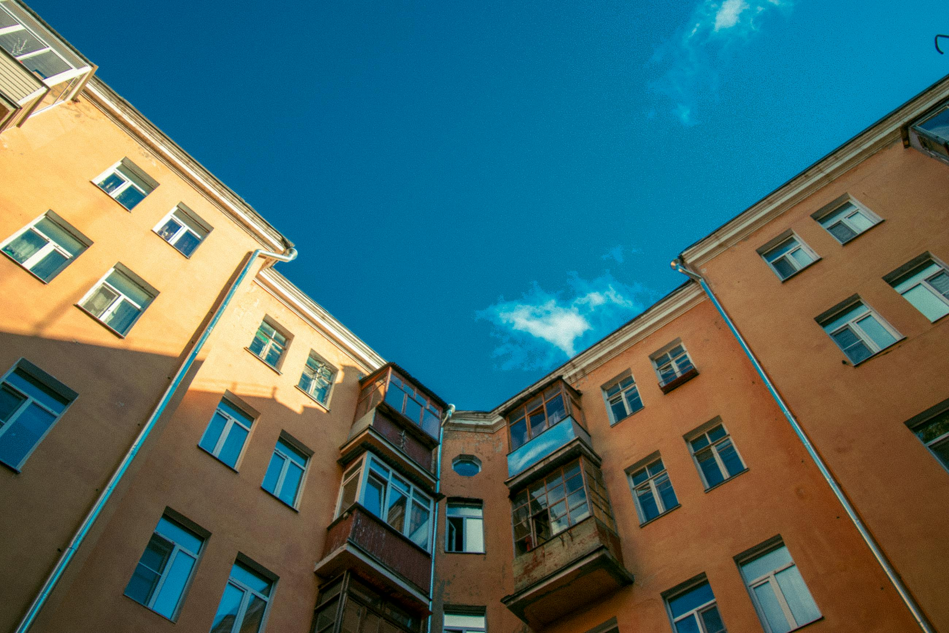 Buildings with many windows against a bright blue sky.